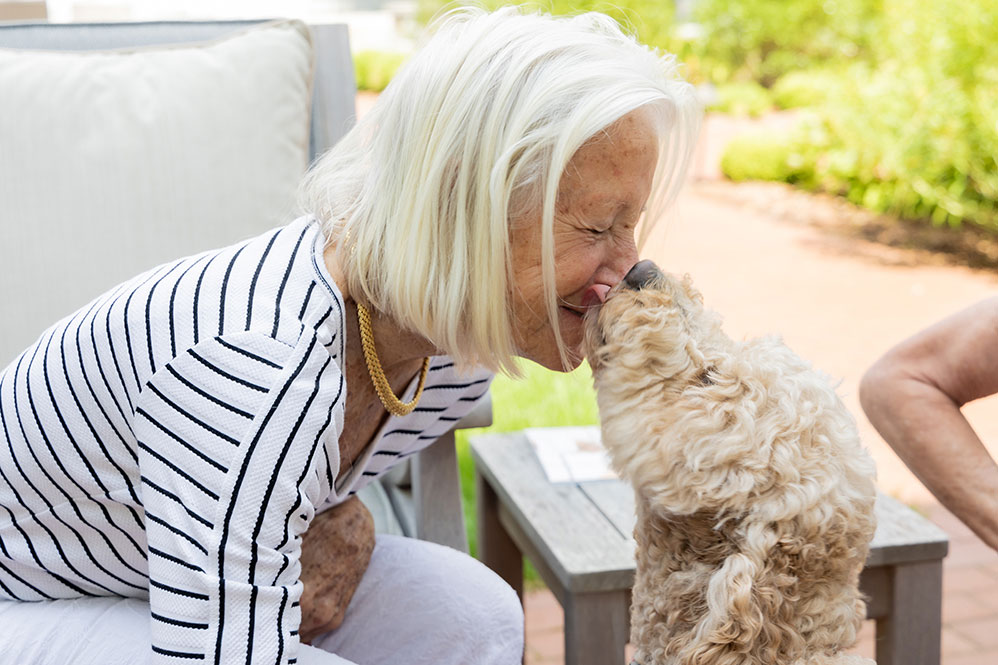 Senior woman getting a dog kiss